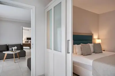 a bedroom with a bed and a living room at Atlantica Aeneas Resort in Ayia Napa