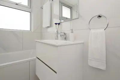 a white bathroom with a sink and a mirror at Villa Harmonia in Protaras