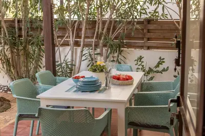 a white table and chairs with a bowl of tomatoes at Villa Ionion 27 in Ayia Napa