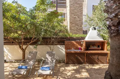 a patio with two chairs and a table and a sink at Villa Ionion 27 in Ayia Napa