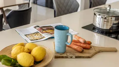a table with a plate of fruits and vegetables and a blue mug at Diamond villas in Protaras