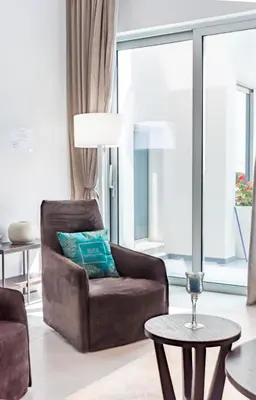 a living room with a chair and a table at Seafront Villa Maya by Ruidoso Luxury in Ayia Napa