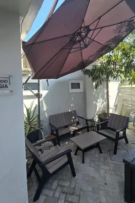 a patio with two benches and an umbrella at Studio Anastasia in Limassol