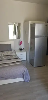 a bedroom with a bed and a refrigerator at Studio Anastasia in Limassol