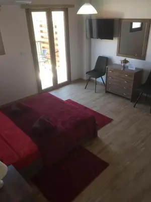 a bedroom with a red bed and a dresser and a television at Love Holiday Suite 1 in Tris Elies