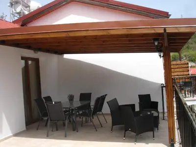a patio with a table and black chairs at Love Holiday Suite 2 in Tris Elies