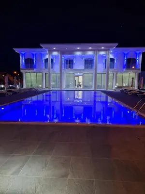 a house with a swimming pool at night at MAXOR PALACE in Protaras