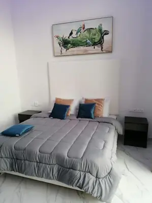 a bedroom with a large bed with blue pillows at MAXOR PALACE in Protaras