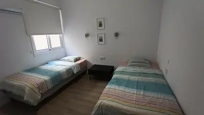 a bedroom with two beds and a window at Sunorama Waterfront Apartment in Larnaka