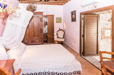 a bedroom with a white bed and a table at Our House in Vavla