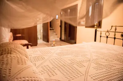 a close up of a bed with a white comforter at Our House in Vavla
