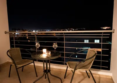 a table with two chairs and a candle on a balcony at Glabur Stays - The Sunny Atelier - Nicosia City, Free Parking & Wifi, Welcomes You!!! in Nicosia
