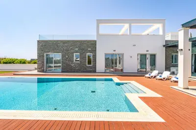a villa with a swimming pool and a house at Seafront Villa Cecelia by Ruidoso Luxury in Ayia Napa