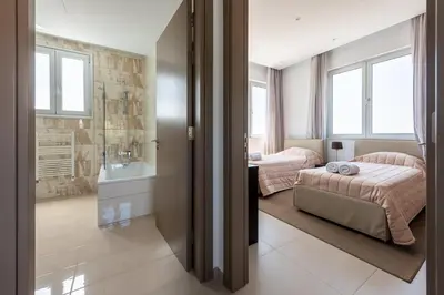 a bedroom with two beds and a bathroom at Villa Dione by Ruidoso Luxury in Ayia Napa