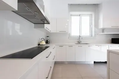 a white kitchen with white cabinets and a sink at Villa Dione by Ruidoso Luxury in Ayia Napa
