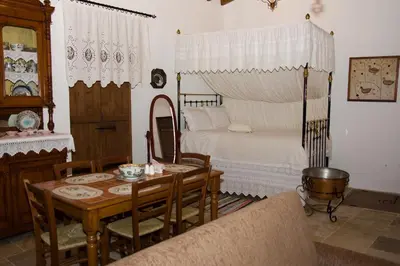 a living room with a table and a bed at Xenios Cottages in Lofou