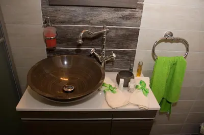 a bathroom sink with a wooden bowl sink at Xenios Cottages in Lofou