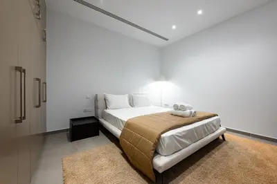 a white bedroom with a bed and a rug at Villa Marsali by Ruidoso Luxury in Ayia Napa