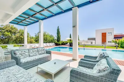 an outdoor patio with couches and a pool at Villa Marsali by Ruidoso Luxury in Ayia Napa