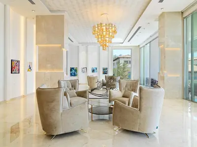 a living room with two chairs and a chandelier at The Tower at St Raphael Resort in Limassol