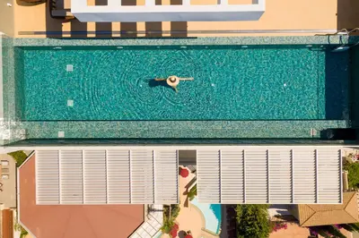 an overhead view of a person swimming in a pool at The Tower at St Raphael Resort in Limassol