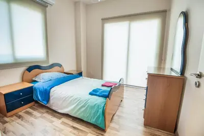 a bedroom with a bed and a dresser and a mirror at Orion Apartment 401 in Larnaka