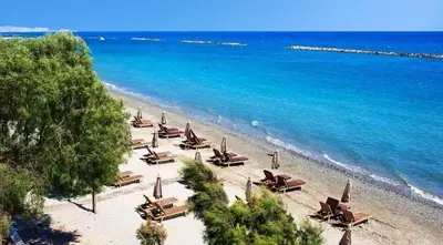 a beach with lounge chairs and the ocean at Seafront - 2 bedroom Modern in Limassol