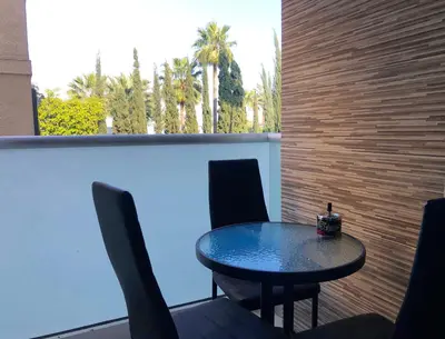 a table and chairs sitting on a patio with a wall at Seafront - 2 bedroom Modern in Limassol