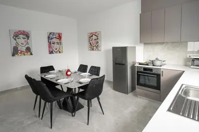 a kitchen with a table and chairs in a kitchen at Bellagio Napa Suites in Ayia Napa