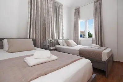 a bedroom with two beds and a window at Elite Luxury Villa in Paralimni