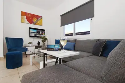 a living room with a couch and a table with a wine glass at Elite Luxury Villa in Paralimni