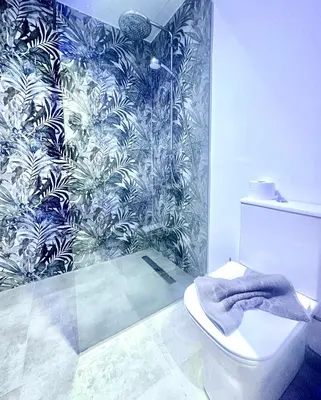 a bathroom with a toilet and a tropical wallpaper at Sun Plaza Suites - Adults Only in Ayia Napa