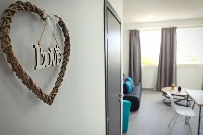 a heart shaped mirror hanging on a wall in a living room at Ayia Napa Boutique Apartments in Ayia Napa