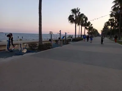 a group of people walking on a sidewalk near the beach at Limassol Hestia Boutique Apartment in Limassol