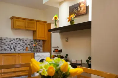 a kitchen with a table with flowers on it at Limassol Hestia Boutique Apartment in Limassol