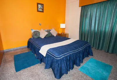 a bedroom with a bed with blue and orange walls at Limassol Hestia Boutique Apartment in Limassol