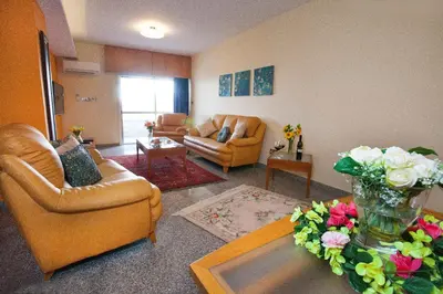 a living room with two chairs and a table with flowers at Limassol Hestia Boutique Apartment in Limassol