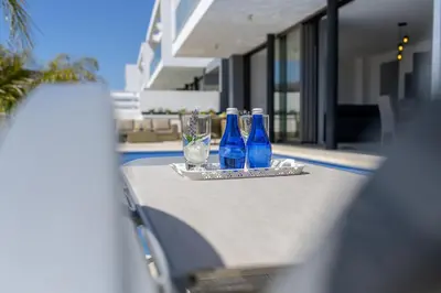 a table with three blue glasses and a tray at Protaras Royal Pearl Villa 7 in Protaras