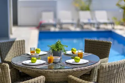 a table with plates of food and drinks on it at Protaras Royal Pearl Villa 7 in Protaras