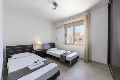 a bedroom with two beds and a window at Protaras Palm Villa 54 in Protaras