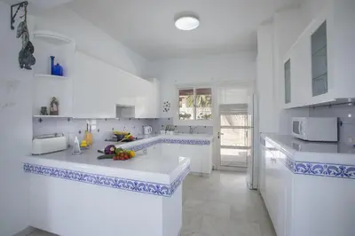 a white kitchen with blue and white tiles at Villa in Ayia Napa with a pool! in Ayia Napa