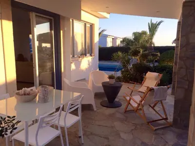 a patio with a white dining table and chairs at Villa in Ayia Napa with a pool! in Ayia Napa