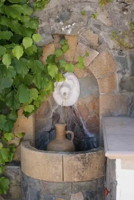 a stone wall with a vase in a stone niche at ATRATSA Mountain Suites in Kalopanayiotis