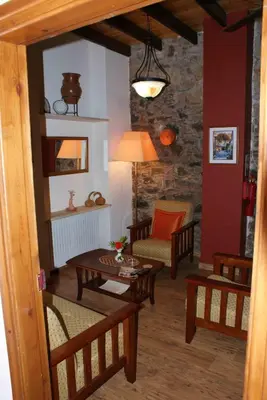 a living room with a table and a chair at ATRATSA Mountain Suites in Kalopanayiotis