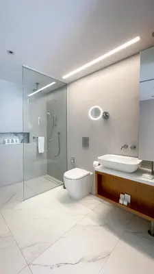 a bathroom with a toilet and a sink and a shower at Radisson Beach Resort Larnaca in Larnaka