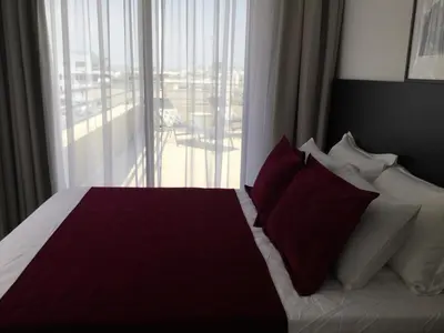 a bedroom with a bed with red and white pillows at A.V Central Apartment in Larnaka