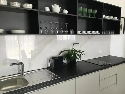a kitchen with a sink and shelves with glasses at A.V Central Apartment in Larnaka