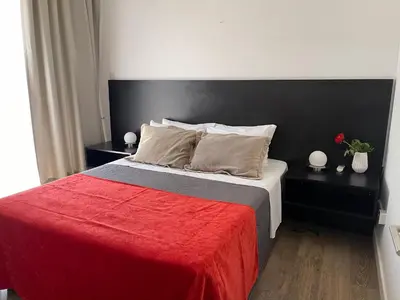 a bedroom with a large bed with a red blanket at A.V Central Apartment in Larnaka