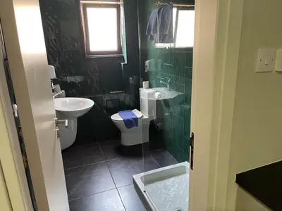 a green bathroom with a toilet and a sink at A.V Central Apartment in Larnaka