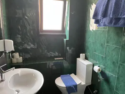 a bathroom with a white toilet and a sink at A.V Central Apartment in Larnaka